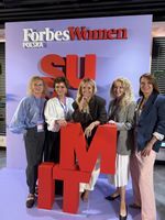 Paulina Kruk with other participants in front of the Forbes Women Polska backdrop at the first Forbes Women Summit in Warsaw