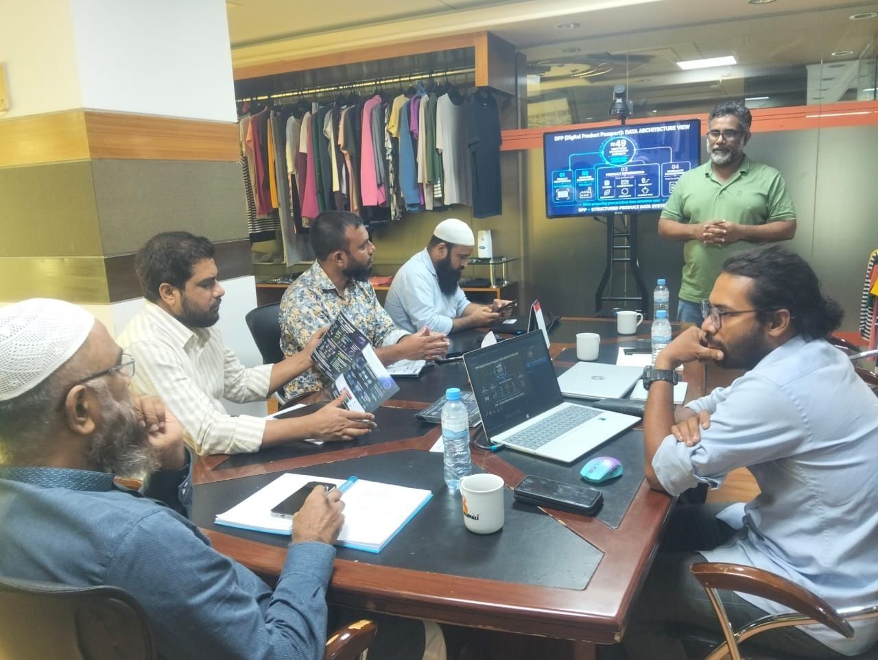 Garment industry professionals discussing Digital Product Passport data architecture during a factory-level meeting in Bangladesh